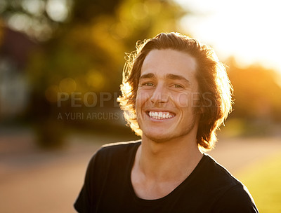 Buy stock photo Portrait of a handsome young man standing outside in the sun