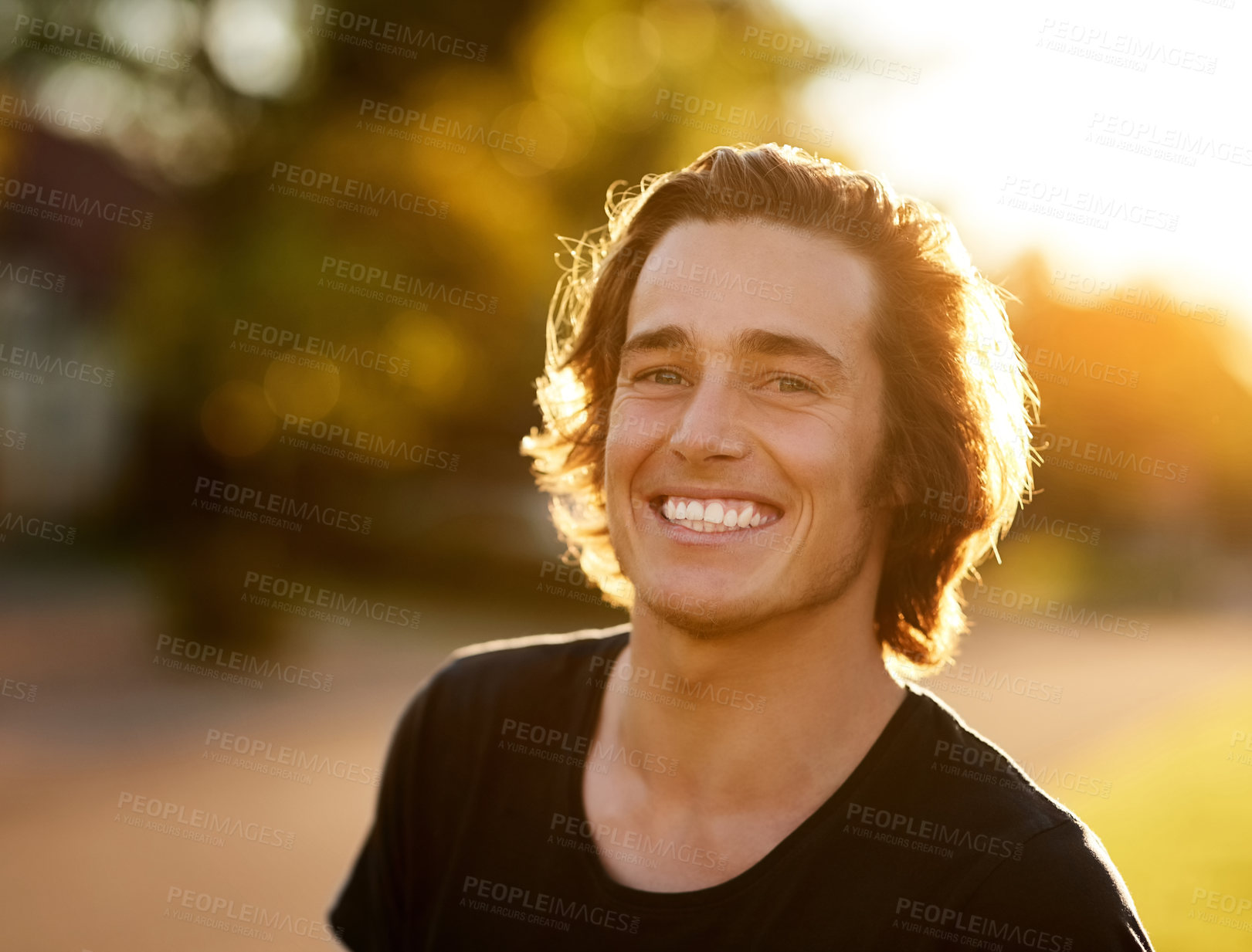 Buy stock photo Portrait of a handsome young man standing outside in the sun