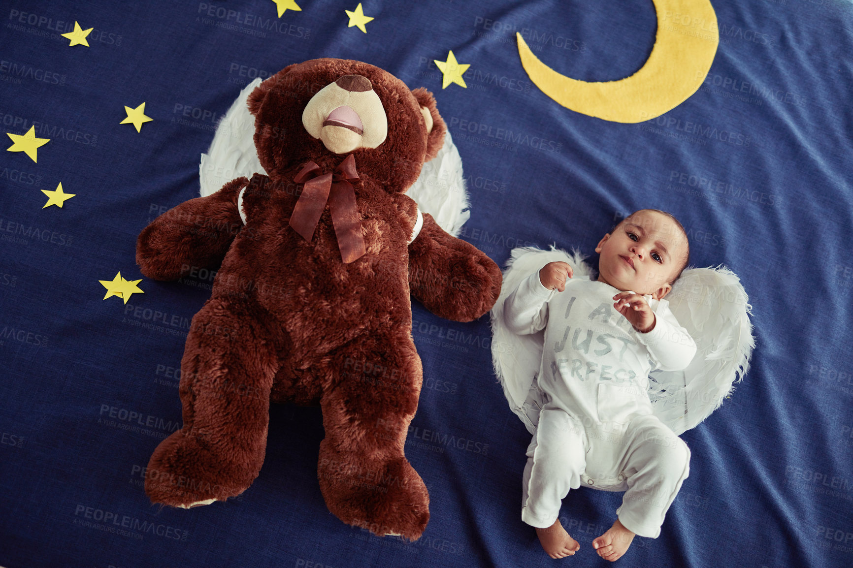 Buy stock photo Concept shot of an adorable baby boy and a teddy bear wearing angel wings against an imaginary night time background