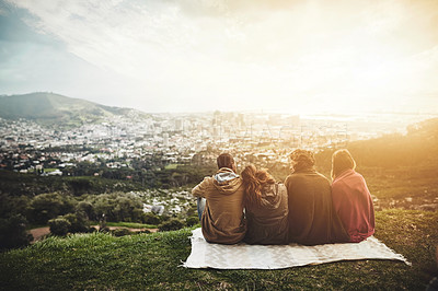 Buy stock photo Rearview shot of a group of friends admiring a view while sitting outside together