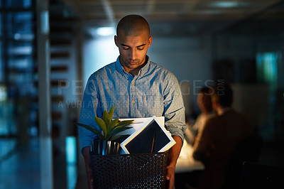 Buy stock photo Cropped shot of a young businessman holding a box of his possessions after getting fired from his job
