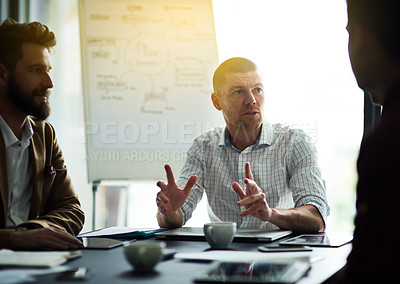 Buy stock photo Cropped shot of a group of colleagues having a meeting in an office
