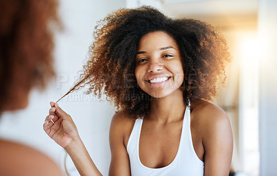 Buy stock photo Shot of an attractive young woman going through her morning haircare routine