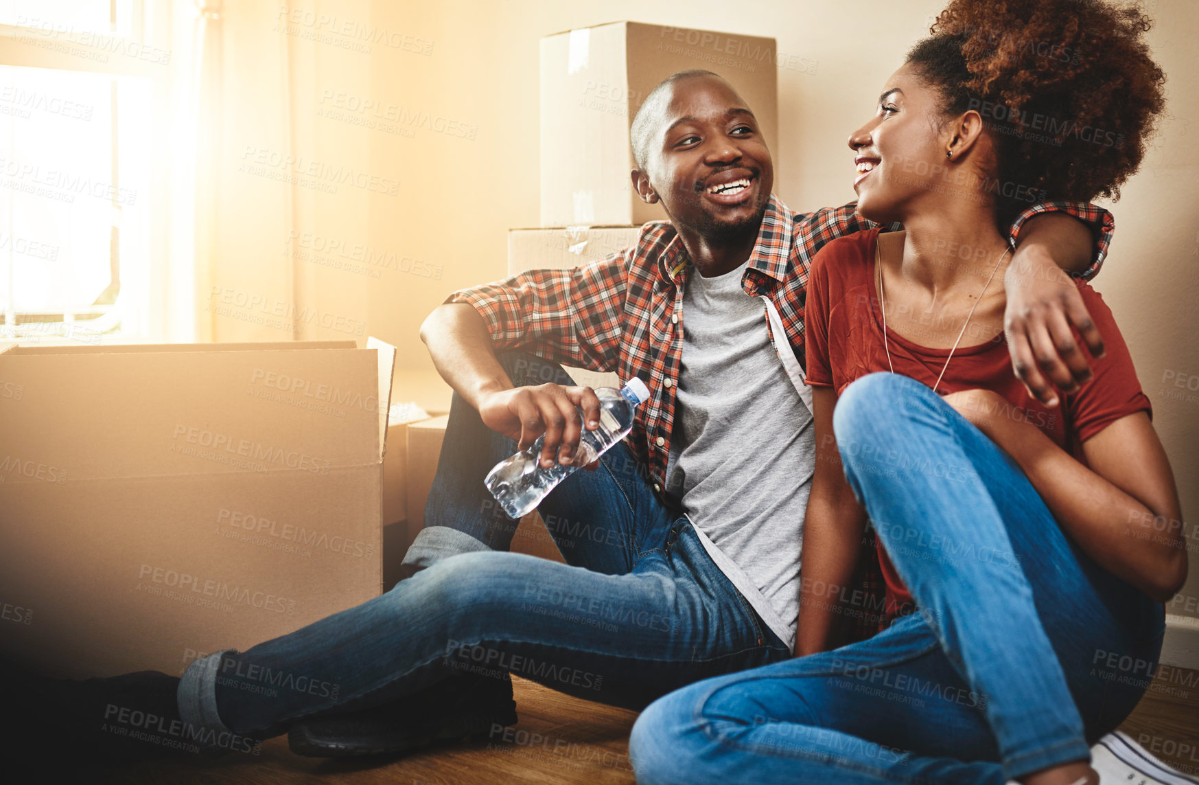 Buy stock photo Black couple, real estate and hug on floor of new house with bonding, support and break or relax from moving. People, homeowner or excited for property investment, dream home or relocation with boxes