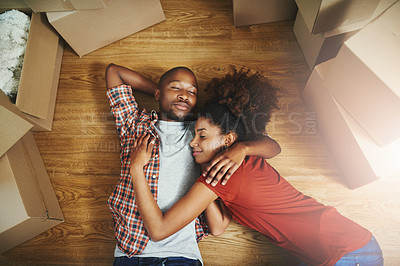 Buy stock photo Sleep, relax and couple on floor in new home with boxes, tired hug and mortgage with high angle. Dream, black man and woman in house with romantic embrace, love and property investment with fatigue.