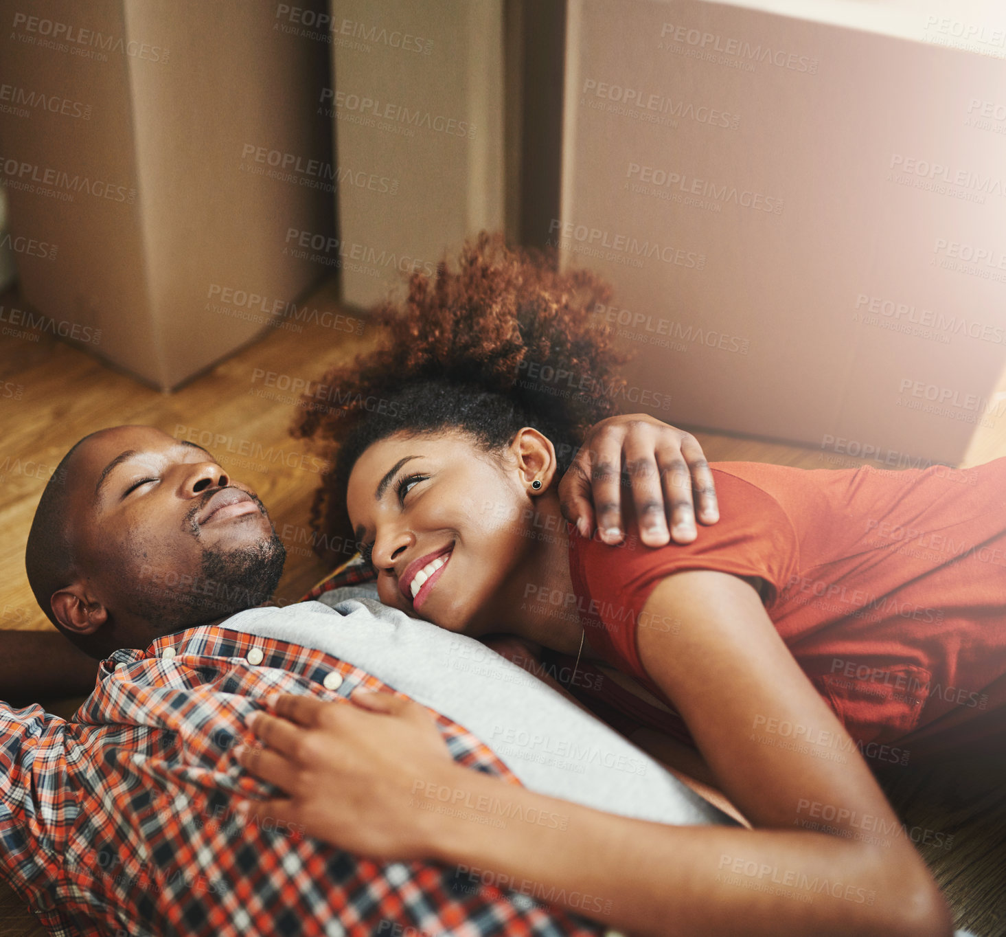 Buy stock photo Sleep, relax and happy couple on floor in new home with moving boxes, tired hug and mortgage. Dream, black man and woman in house with romantic embrace, love and property investment with fatigue.