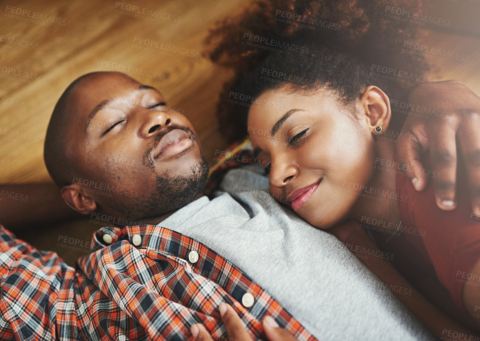 Buy stock photo Black couple, sleeping and relax in dream home on floor for real estate, hug and tired after finishing moving. Resting, man and woman cuddle in new house, calm and peace on break together for love