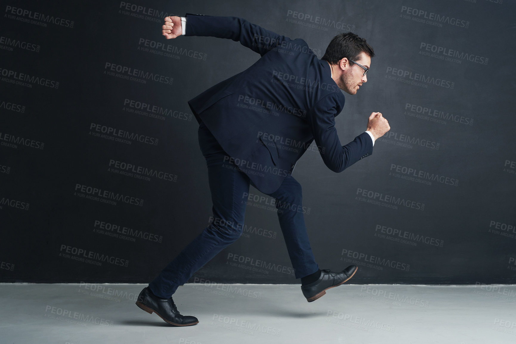 Buy stock photo Studio shot of a businessman running against a gray background