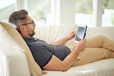 Buy stock photo Shot of a handsome mature man relaxing on the sofa at home
