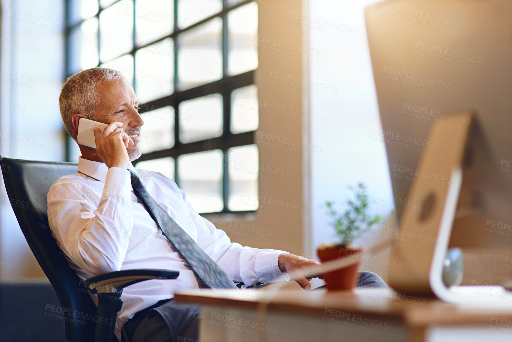 Buy stock photo Shot of a mature businessman talking on his cellphone in an office