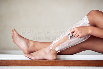Buy stock photo Shot of an unidentifiable woman shaving her legs at home