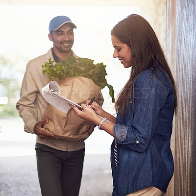 Buy stock photo Cropped shot of a courier making a delivery to a customer at her home