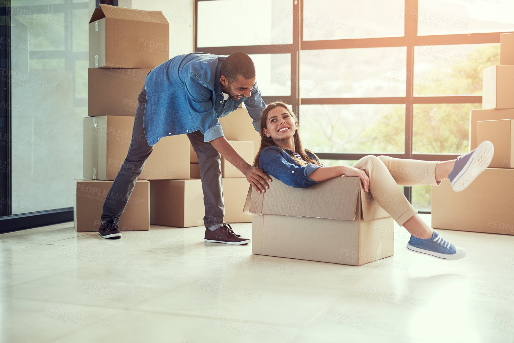 Buy stock photo New home, playful and couple with box for moving for house, property mortgage and real estate investment. Homeowner, marriage and happy man and woman celebrate for relocation, packing and rental