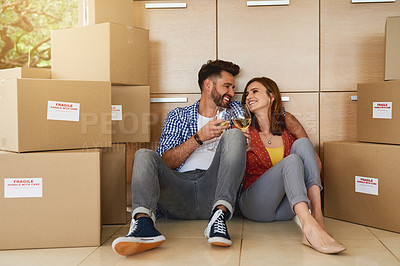 Buy stock photo Shot of a young couple celebrating their move into a new home