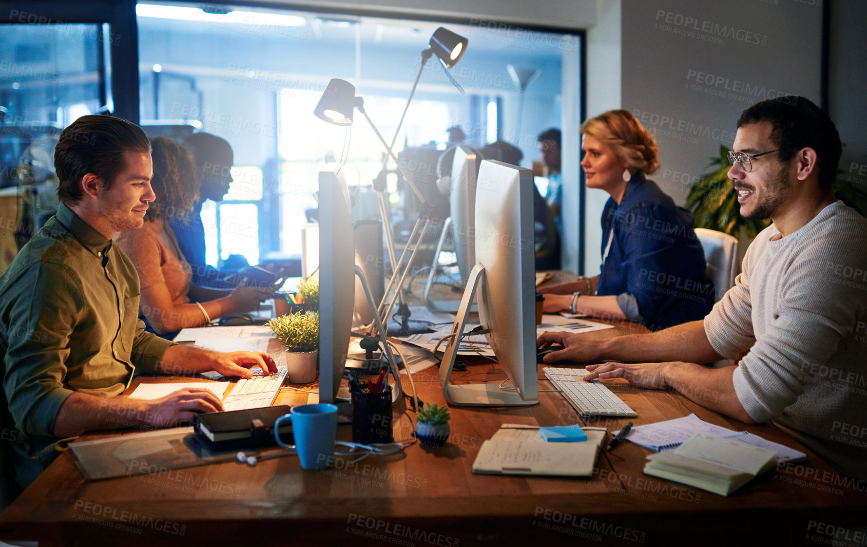 Buy stock photo Shot of a team of young businesspeople working late in the office
