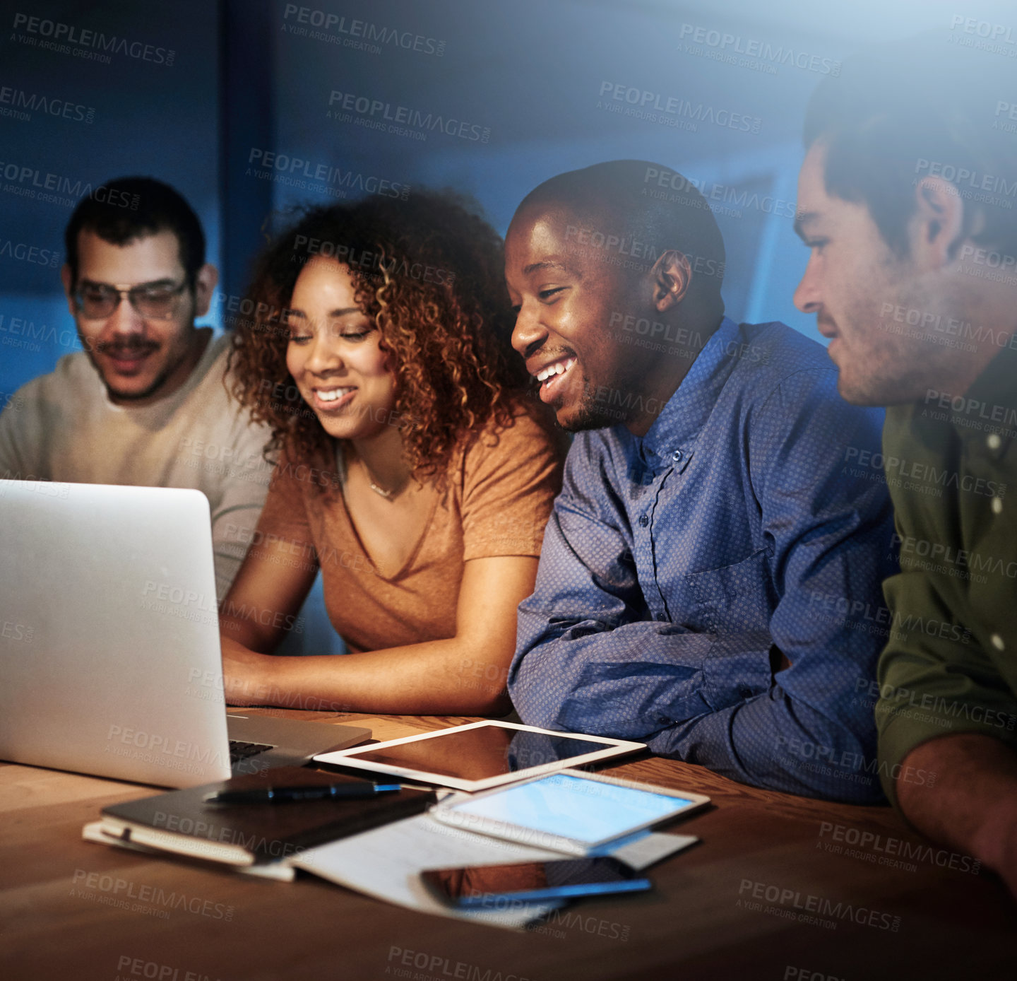 Buy stock photo Shot of a team of young businesspeople working late in the office