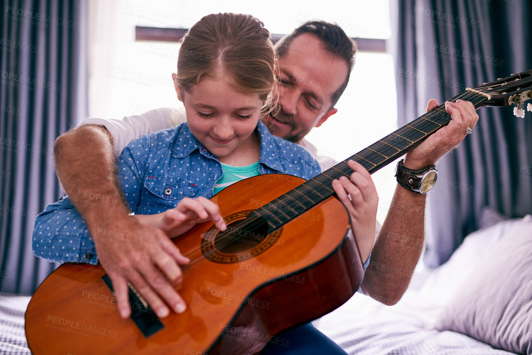 Buy stock photo Cropped shot of a father and daughter playing the guitar together at home