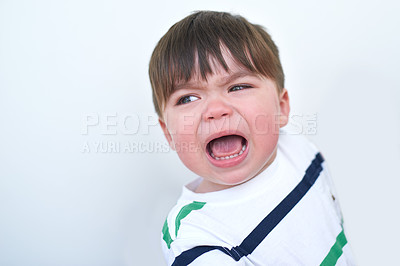 Buy stock photo Shot of an unhappy baby boy crying alone