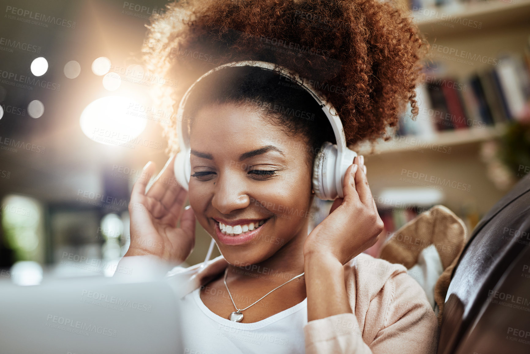 Buy stock photo Happy, laptop and black woman on sofa with headphones, smile and morning streaming in living room. Relax, wellness and girl on couch in home with online music, digital app and computer in apartment.