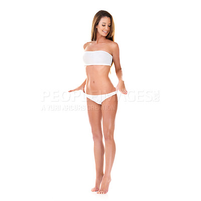 Buy stock photo Studio shot of a beautiful young brunette woman in a white bikini pulling on her waistband isolated on white