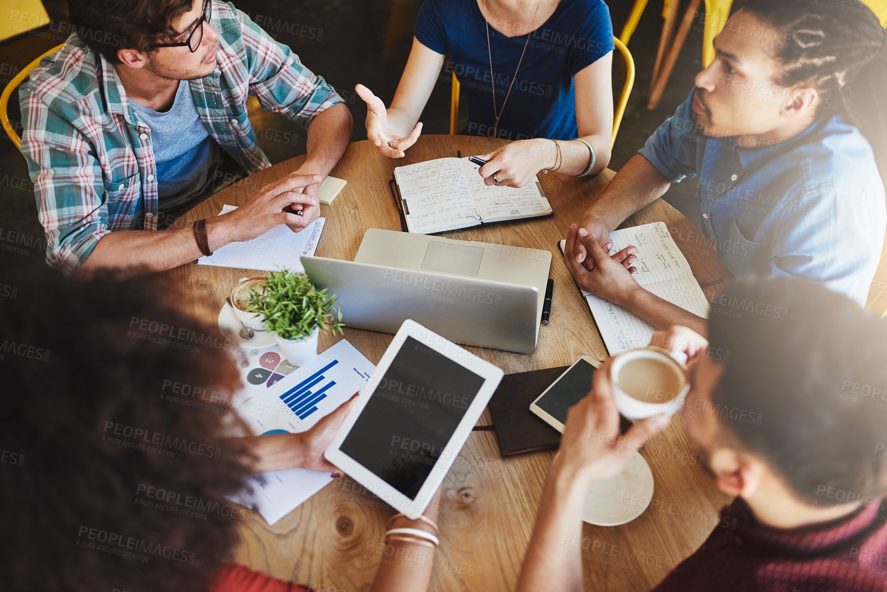 Buy stock photo High angle shot of a group of students studying in a coffee shop