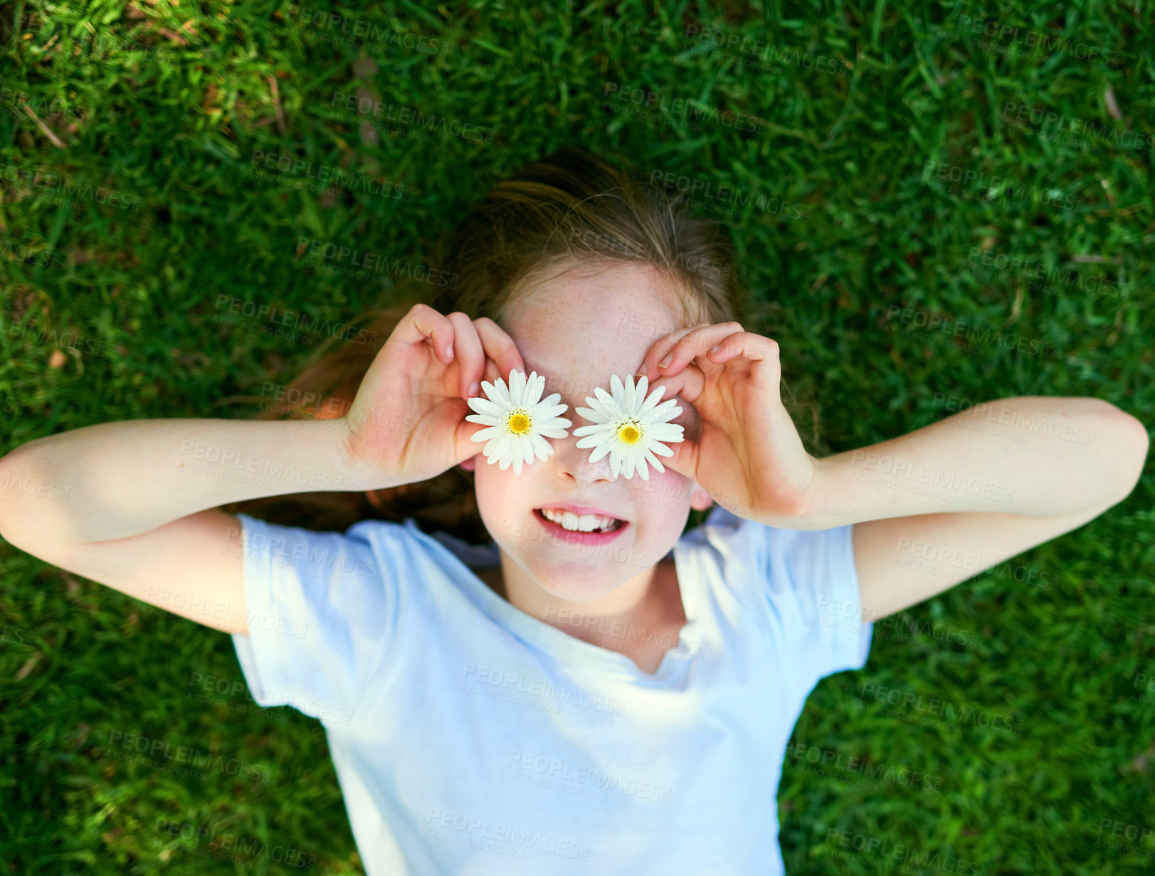 Buy stock photo Flower, eyes and girl child in grass field with top view fun, adventure and playing on explore, journey or countryside travel. Daisy, face and happy kid in a garden with creative petal expression