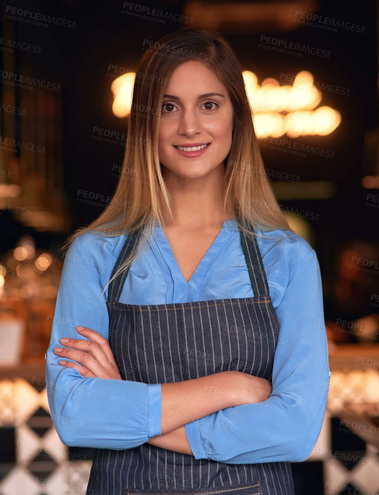 Buy stock photo Cropped portrait of an attractive young woman standing with her arms folded in her coffee shop