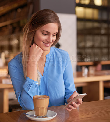 Buy stock photo Cropped shot of an attractive young woman using her cellphone in a coffee shop