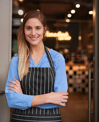 Buy stock photo Cropped portrait of an attractive young woman standing with her arms folded in her coffee shop