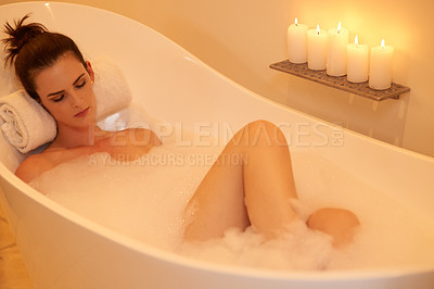 Buy stock photo Woman, relax and bath with candles in home for body care, selfcare and cleaning routine in bathroom. Girl, person and resting in bathtub with foam, wellness and ambient for pamper, zen and hygiene