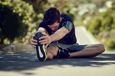 Buy stock photo Full length shot of a young man warming up outdoors before a workout