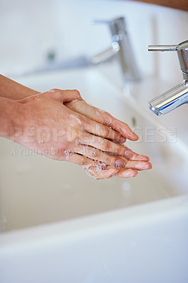 Buy stock photo A cropped shot of a young woman washing her hands in her bathroom