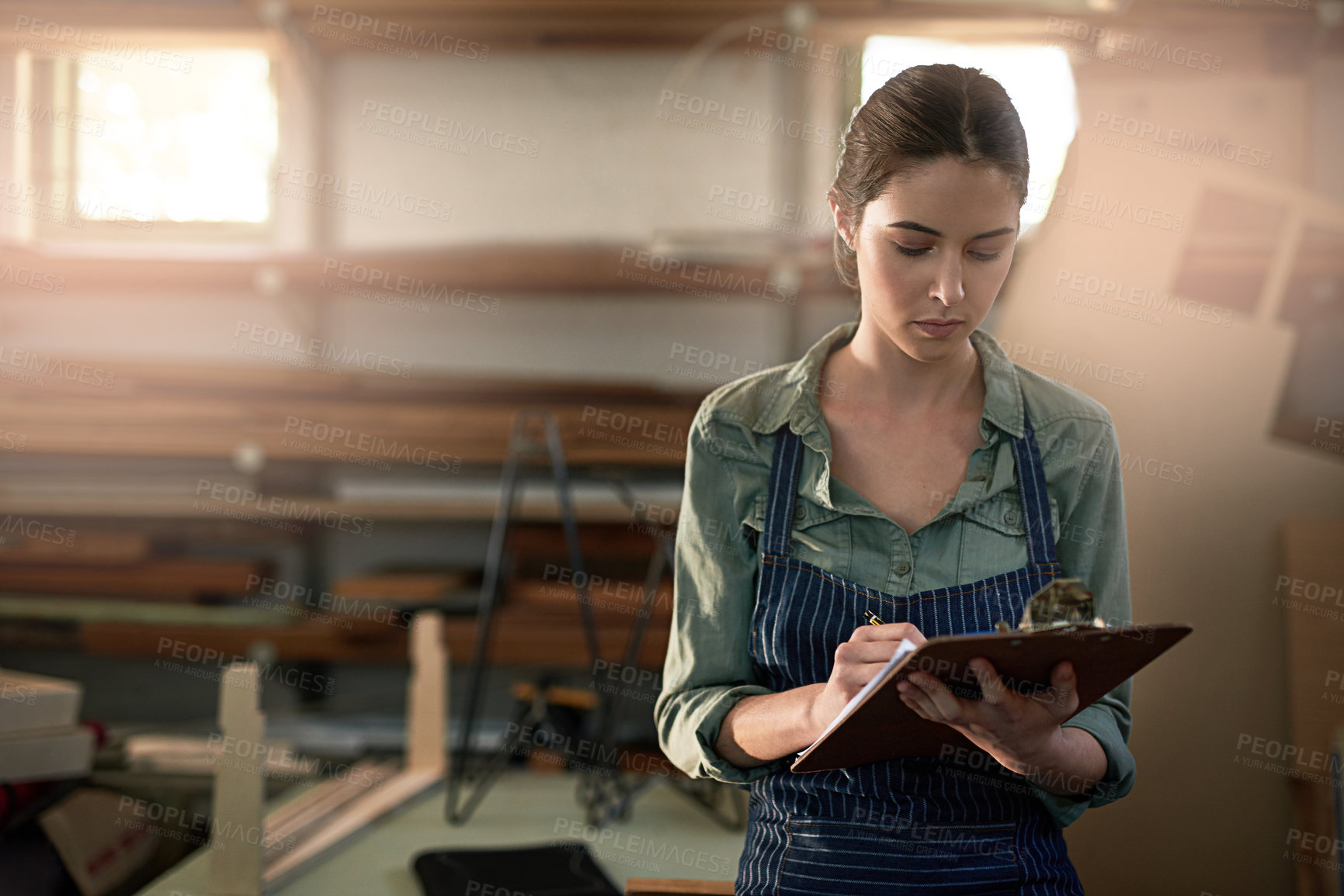 Buy stock photo Craft, woman and clipboard in workshop for wood, planning and stock inspection with writing. Carpenter, girl and paper for maintenance, product checklist and manufacturing inventory in factory