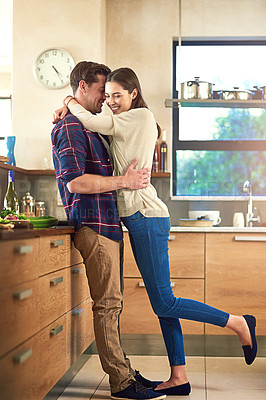 Buy stock photo Shot of an affectionate young couple in their kitchen at home