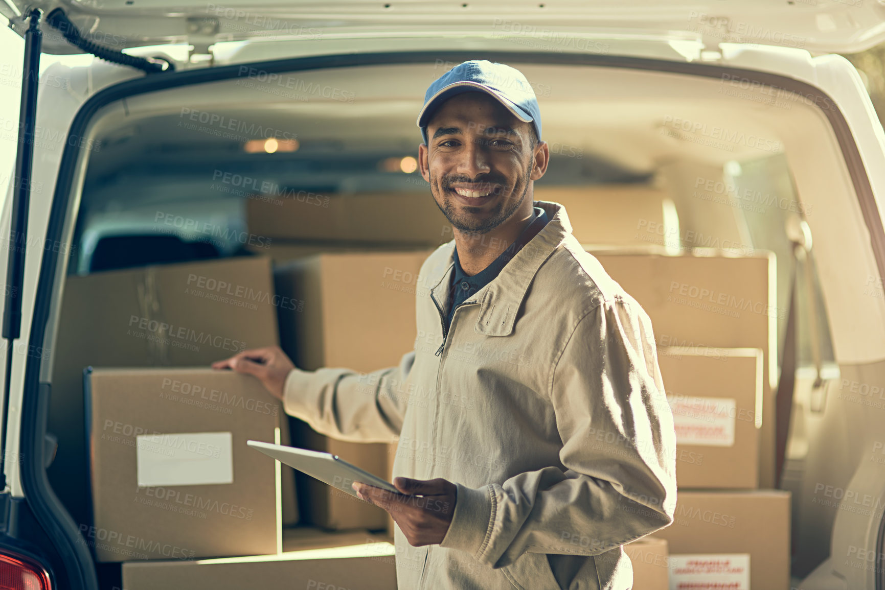 Buy stock photo Portrait of a delivery man using a digital tablet while checking the boxes in his van