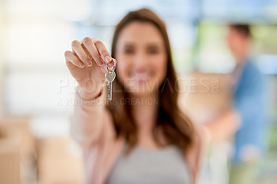 Buy stock photo Portrait of a young woman holding up the keys to a new home with her boyfriend in the background