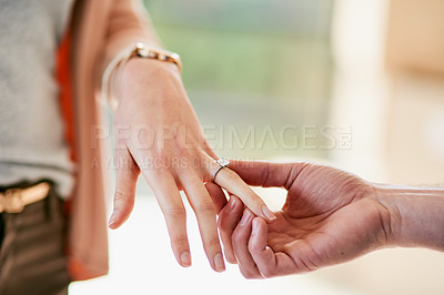 Buy stock photo Closeup shot of a man putting an engagement ring onto his fiancee’s finger