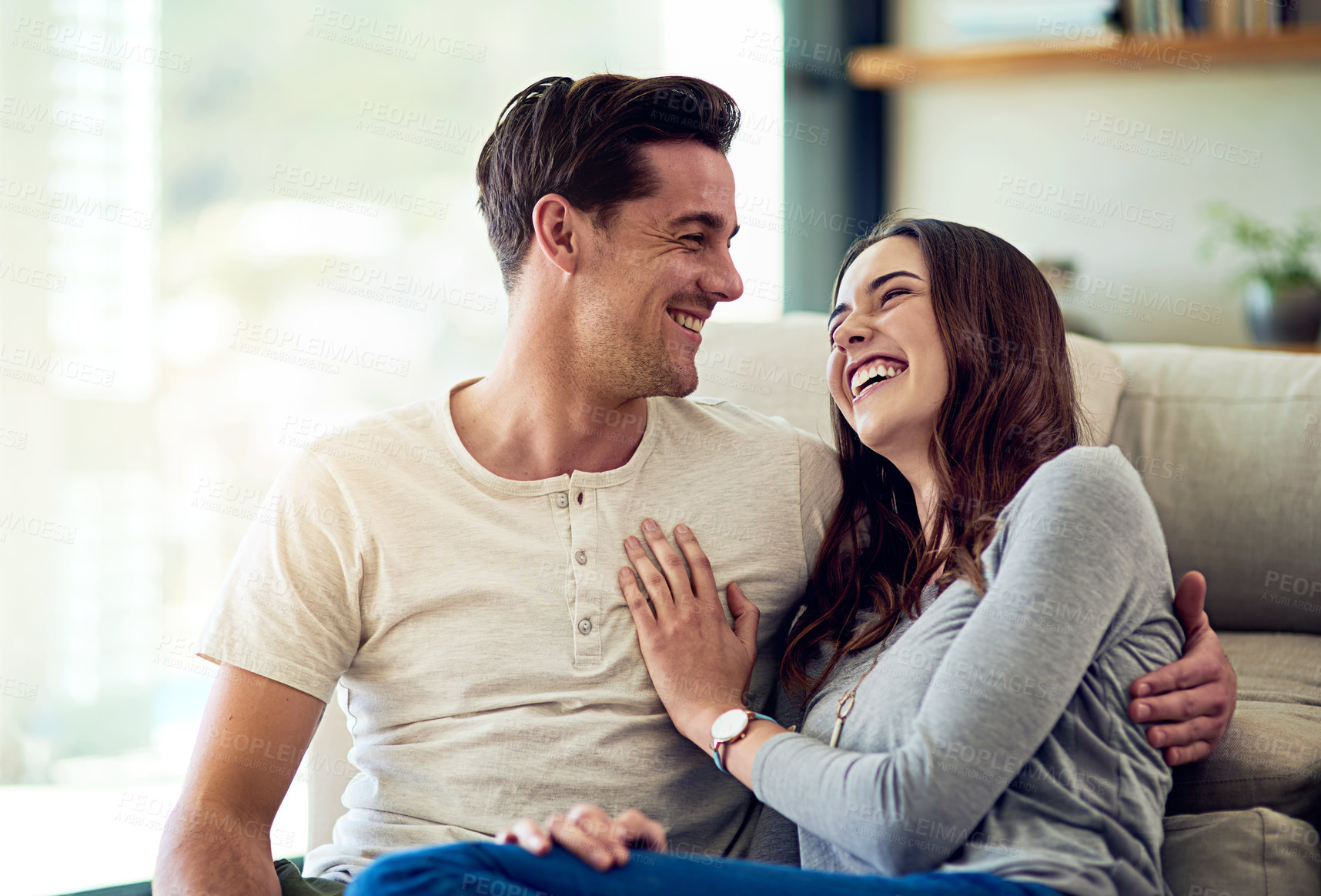 Buy stock photo Shot of a happy young couple relaxing together at home