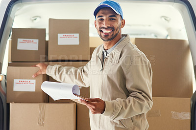 Buy stock photo Cropped portrait of a handsome young delivery man checking his orders for the day
