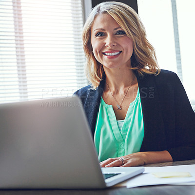 Buy stock photo Portrait of a happy businesswoman using her laptop in the office