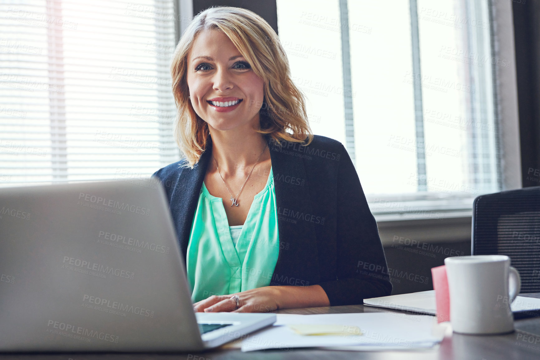 Buy stock photo Portrait of a happy businesswoman using her laptop in the office