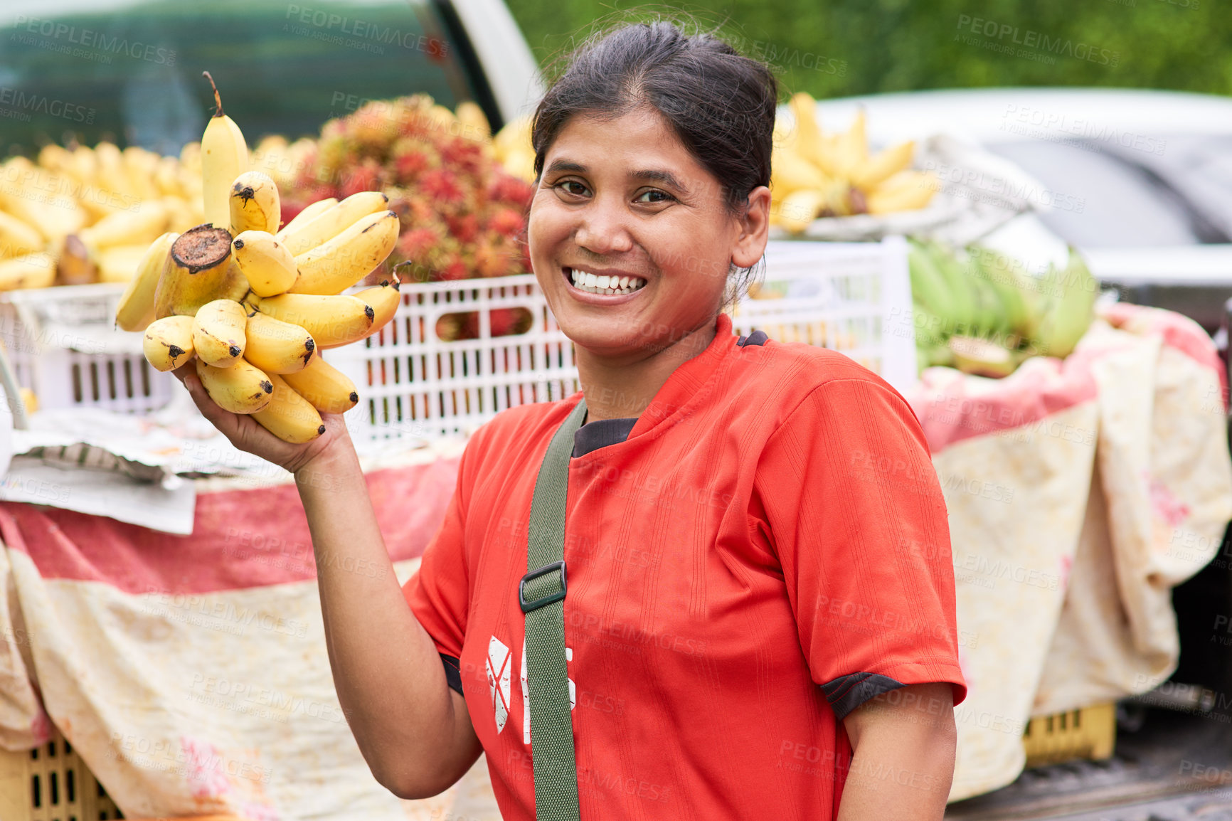 Buy stock photo Portrait of a woman selling bananas at her market stall outside