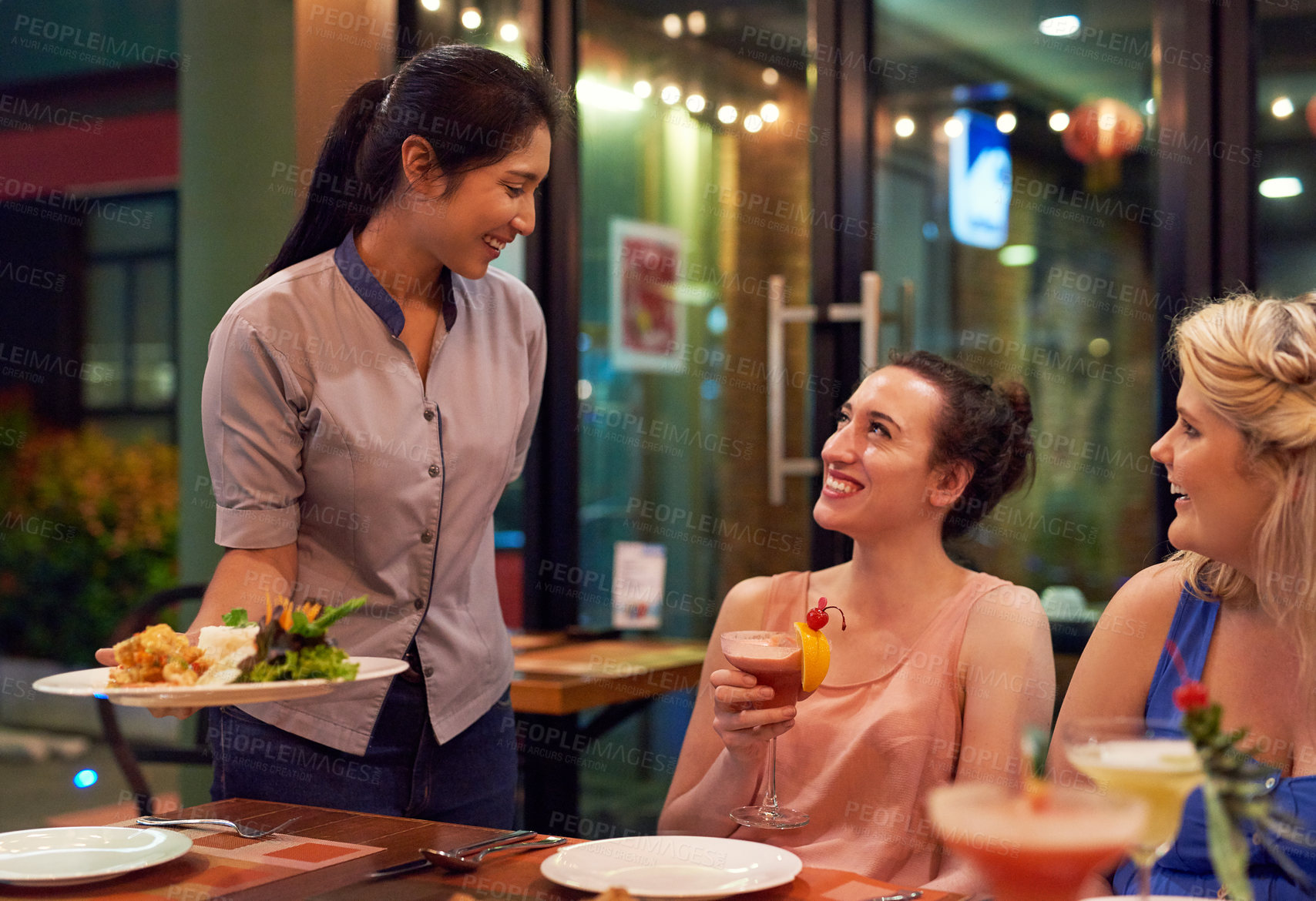 Buy stock photo Cropped shot of a waitress serving customers at a restaurant