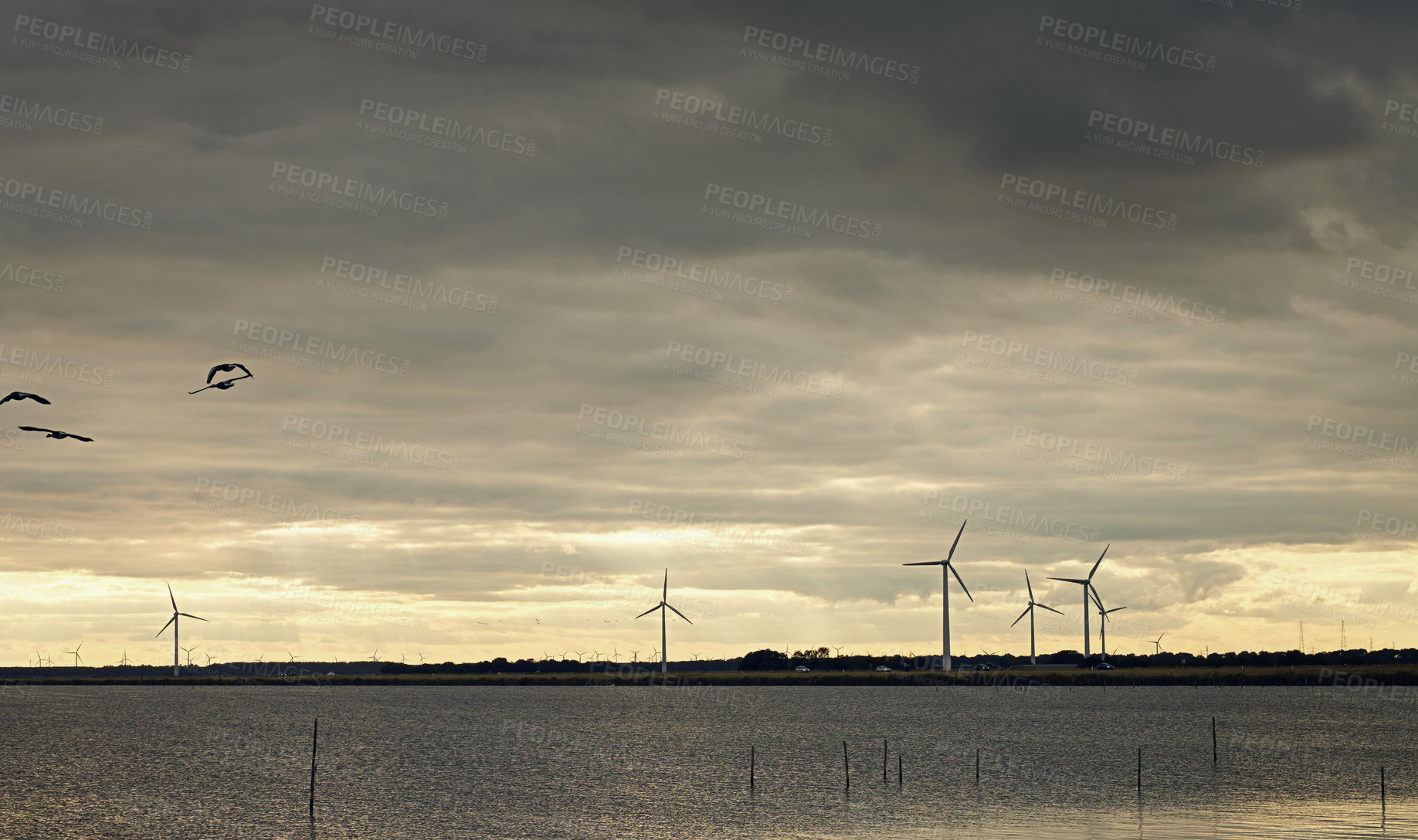 Buy stock photo Wind turbine, sky and electricity farm in production with connectivity, technology and outdoor industrial grid. Renewable energy, windmill field and steel infrastructure for power, system and nature.