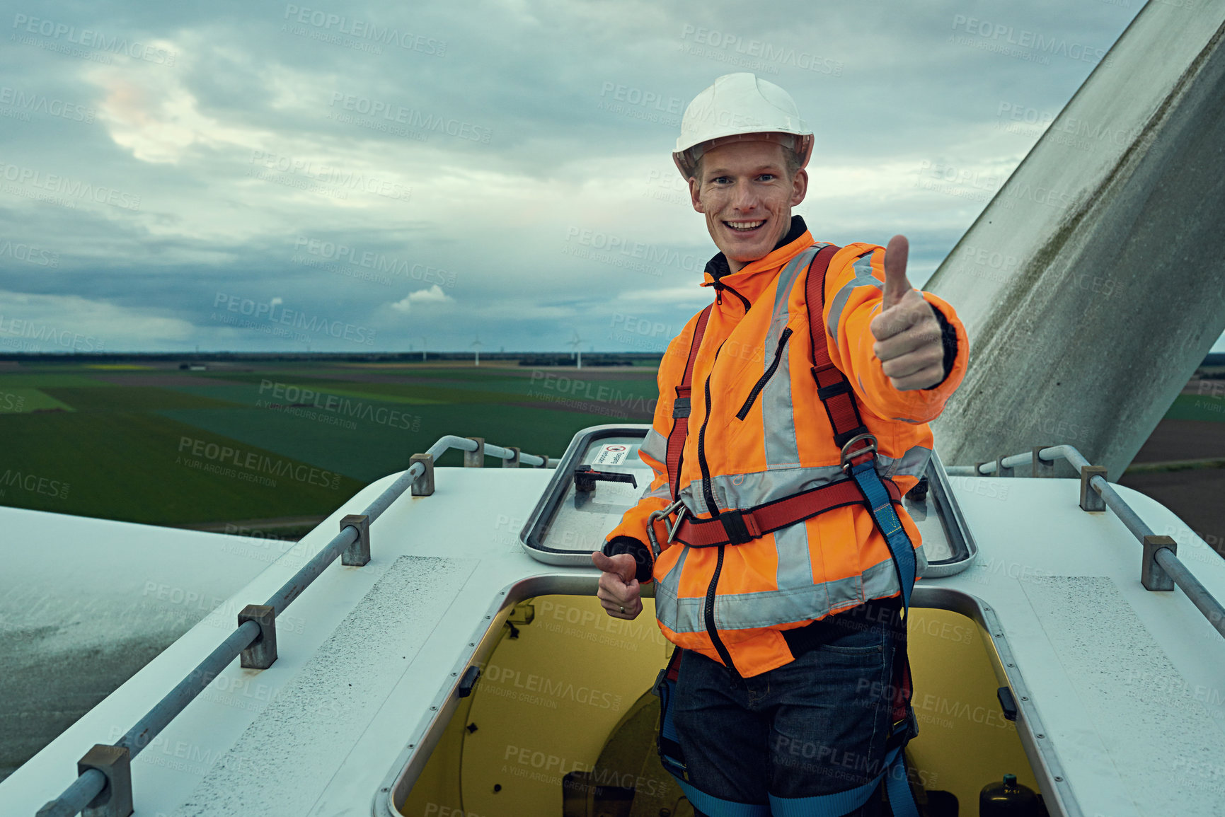 Buy stock photo Wind turbine, thumbs up and portrait of man in electricity maintenance of industrial grid production. Renewable energy, quality assurance and technician with yes hand gesture at electrical windmill.