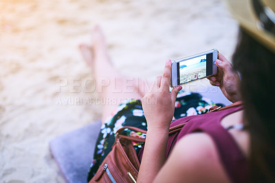 Buy stock photo High angle shot of a young woman taking photographs at the beach