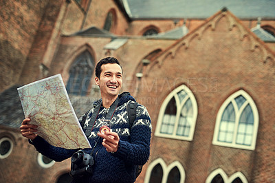 Buy stock photo Cropped shot of a young man looking at a map while on vacation