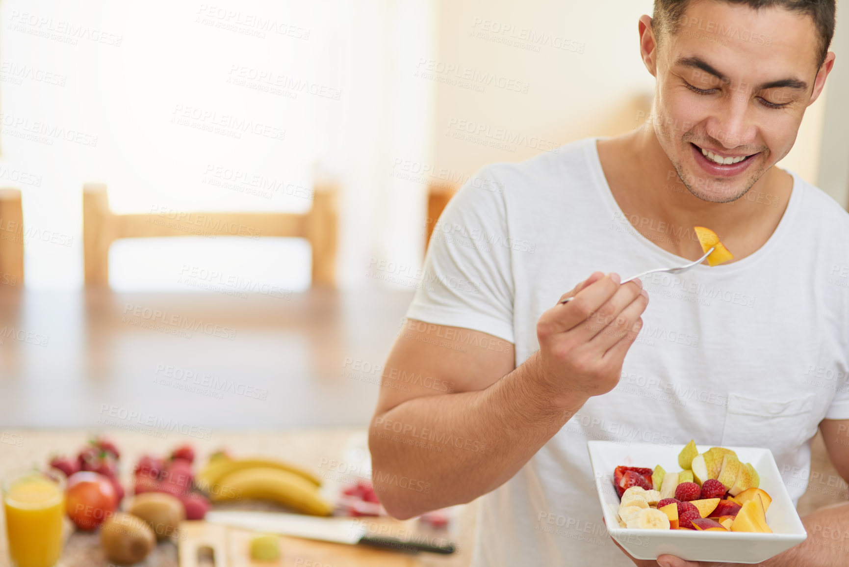 Buy stock photo Cropped shot of a young man eating a fruit salad