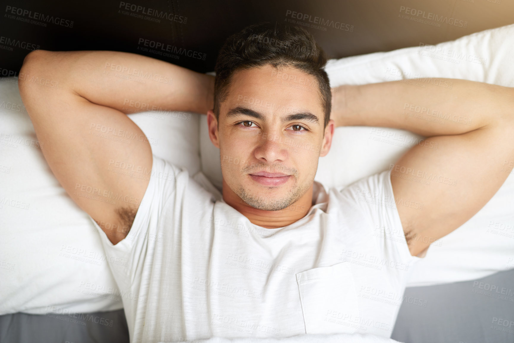 Buy stock photo Cropped shot of a handsome young man lying in bed