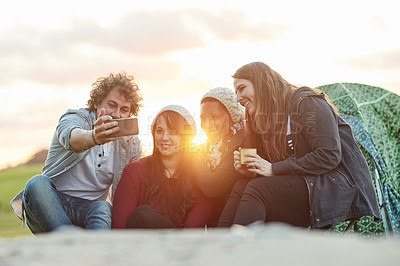 Buy stock photo Shot of a group of friends taking a selfie together while on a weekend camping trip